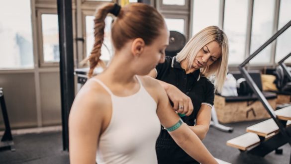 A woman with her trainer, taking measurements.